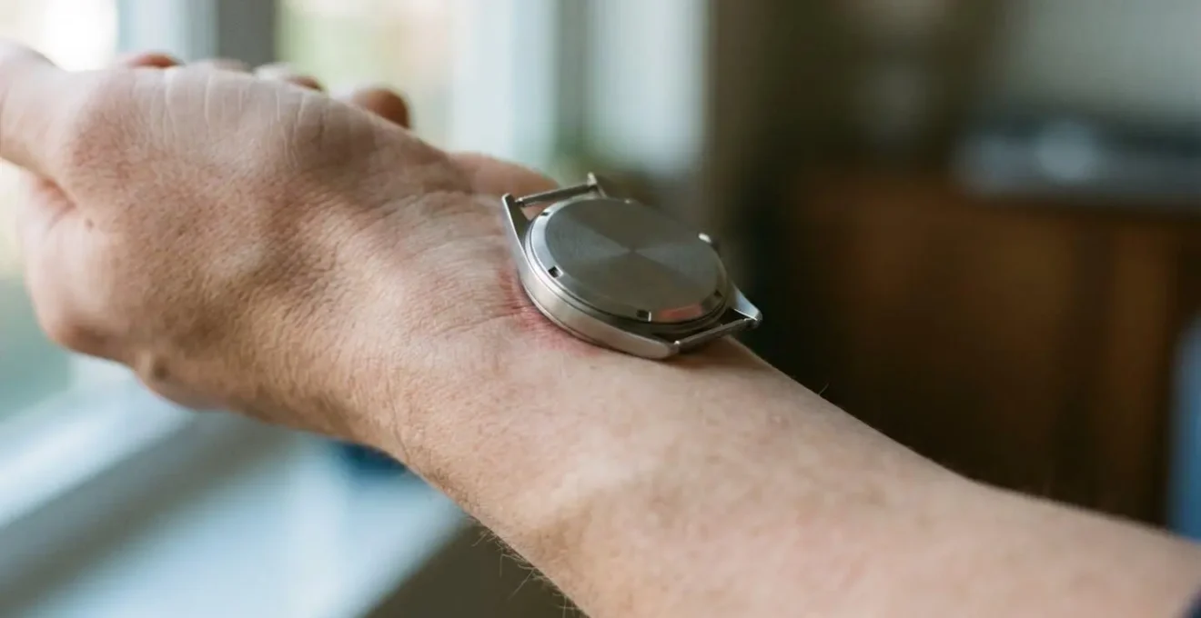 Vue rapprochée d'un poignet portant une montre avec focus sur le contact métal-peau