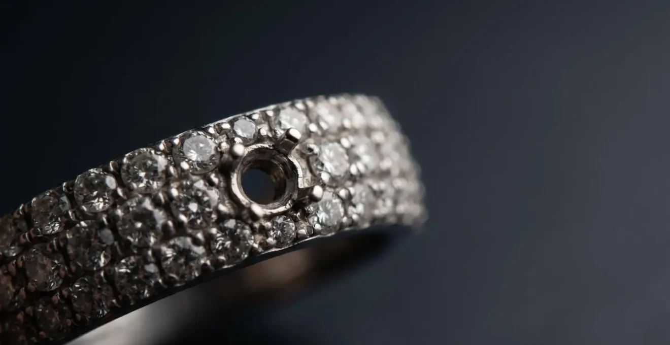 Plan rapproché sur une bague pavée de petits diamants avec un emplacement vide montrant l'effet domino sur les pierres adjacentes fragilisées