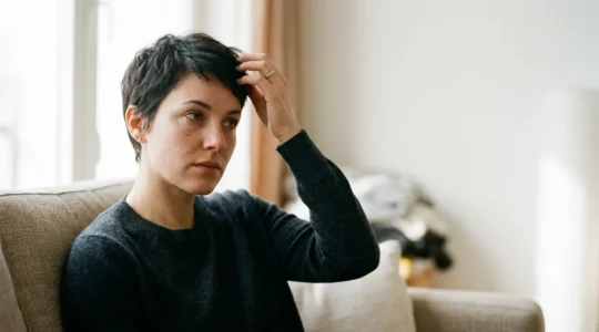 Femme pensive devant miroir après coupe de cheveux radicale symbolisant renouveau psychologique