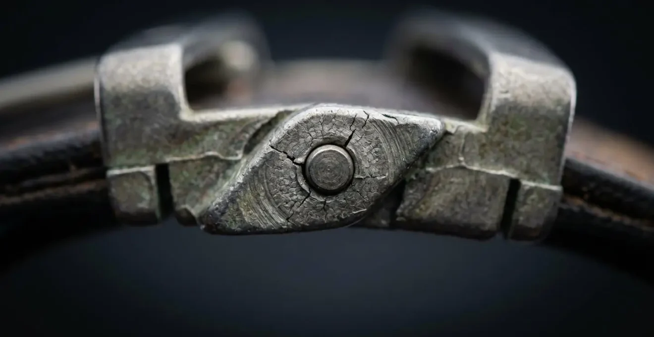 Gros plan macro sur le mécanisme de pivot d'une boucle de ceinture réversible montrant le point de rupture