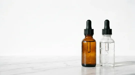 Sérum de skincare vitamine C et rétinol sur fond neutre, composition minimaliste